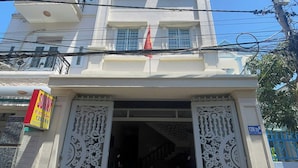 A multi-story building with a central entrance featuring ornate white metal gates. - Sunny Hotel Vung Tau (Ho Chi Minh City)