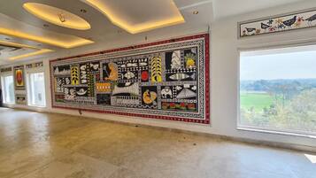 Quarto espaçoso com um grande mural na parede, uma janela ampla com vista e um design de teto moderno.