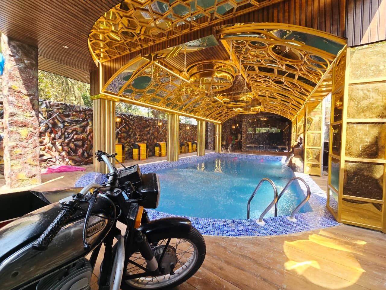 En inomhuspool med ett gyllene tak och en motorcykel parkerad i närheten.