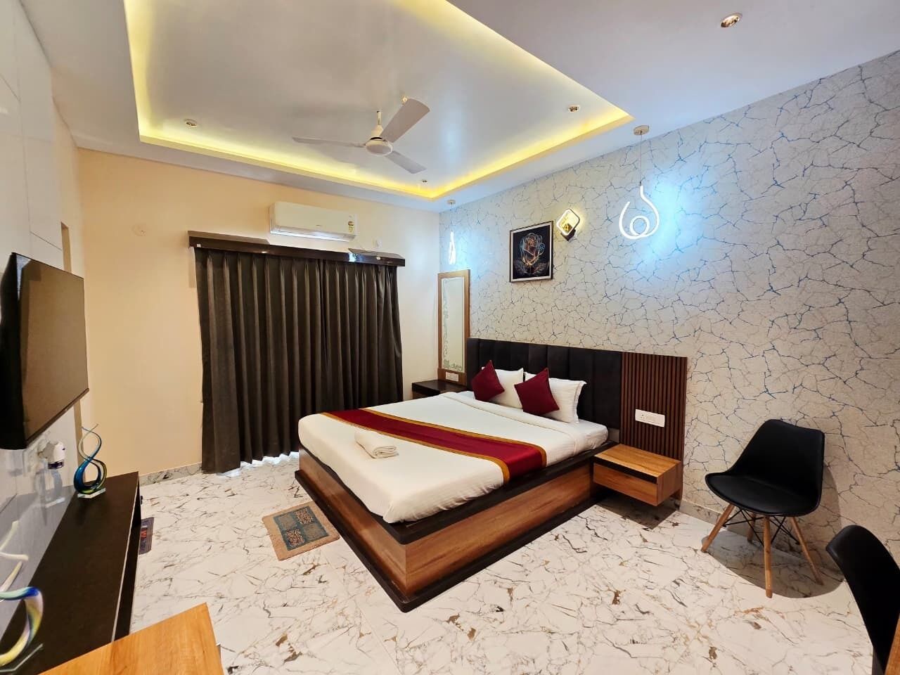 Una habitación de hotel moderna con una cama grande, un escritorio, una silla y un televisor.