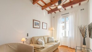 A living room with a sofa, a chair, a glass coffee table, and a lamp. - Casa Major by 3 Villas Menorca (Fornells)