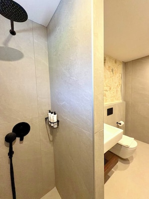 Un bagno moderno con doccia, WC e lavandino.