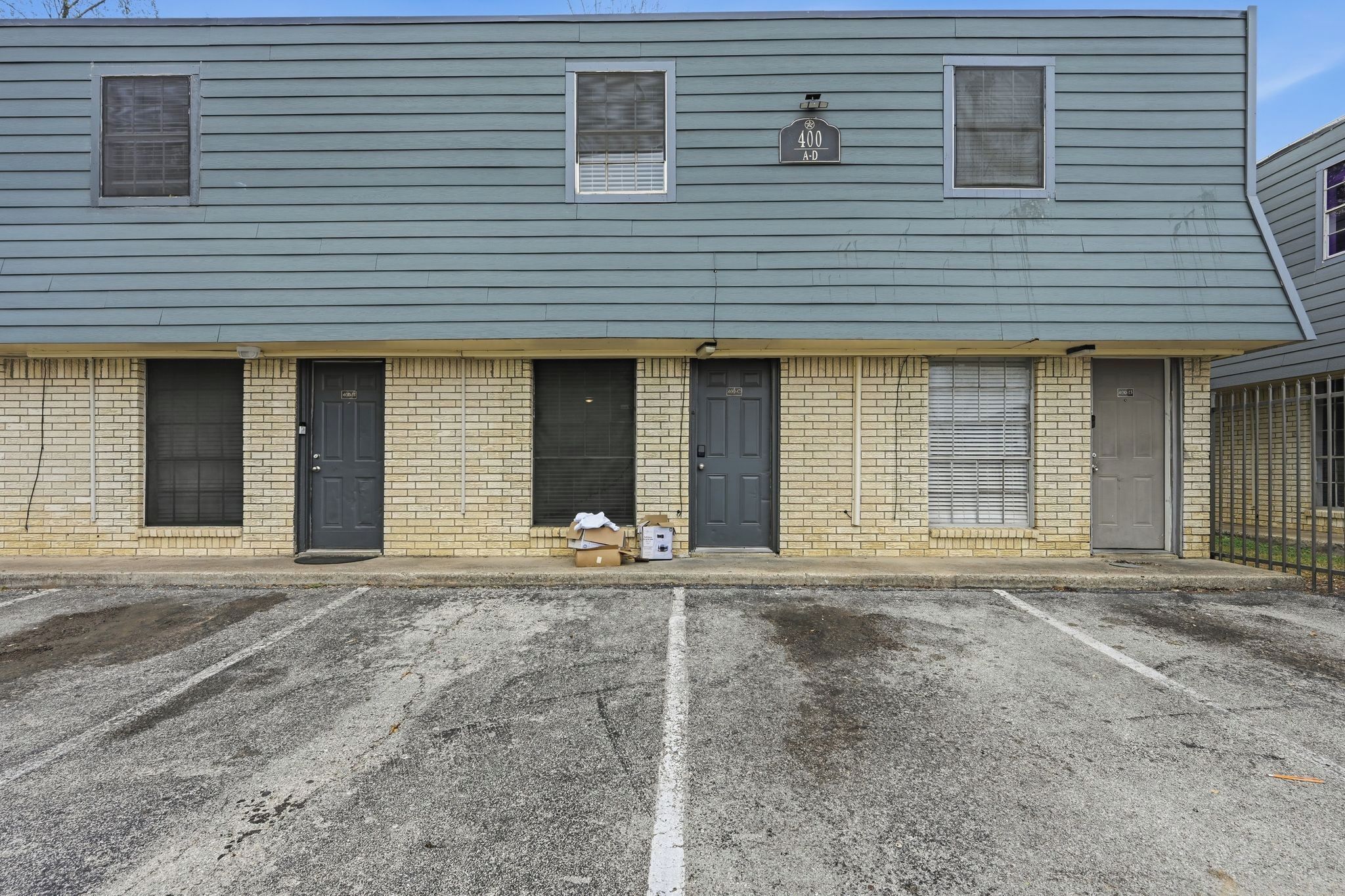 A two-story building with a brick facade, numbered 400, and a parking lot in front.