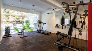 A gym with treadmills, dumbbells, and a weight machine. - Staymaster Solintra 2BHK A301 (Verem)