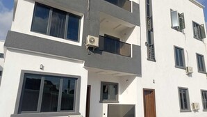 A multi-story building with balconies, large windows, and air conditioning units. - Jasmine Chidera Apartments (Lagos)