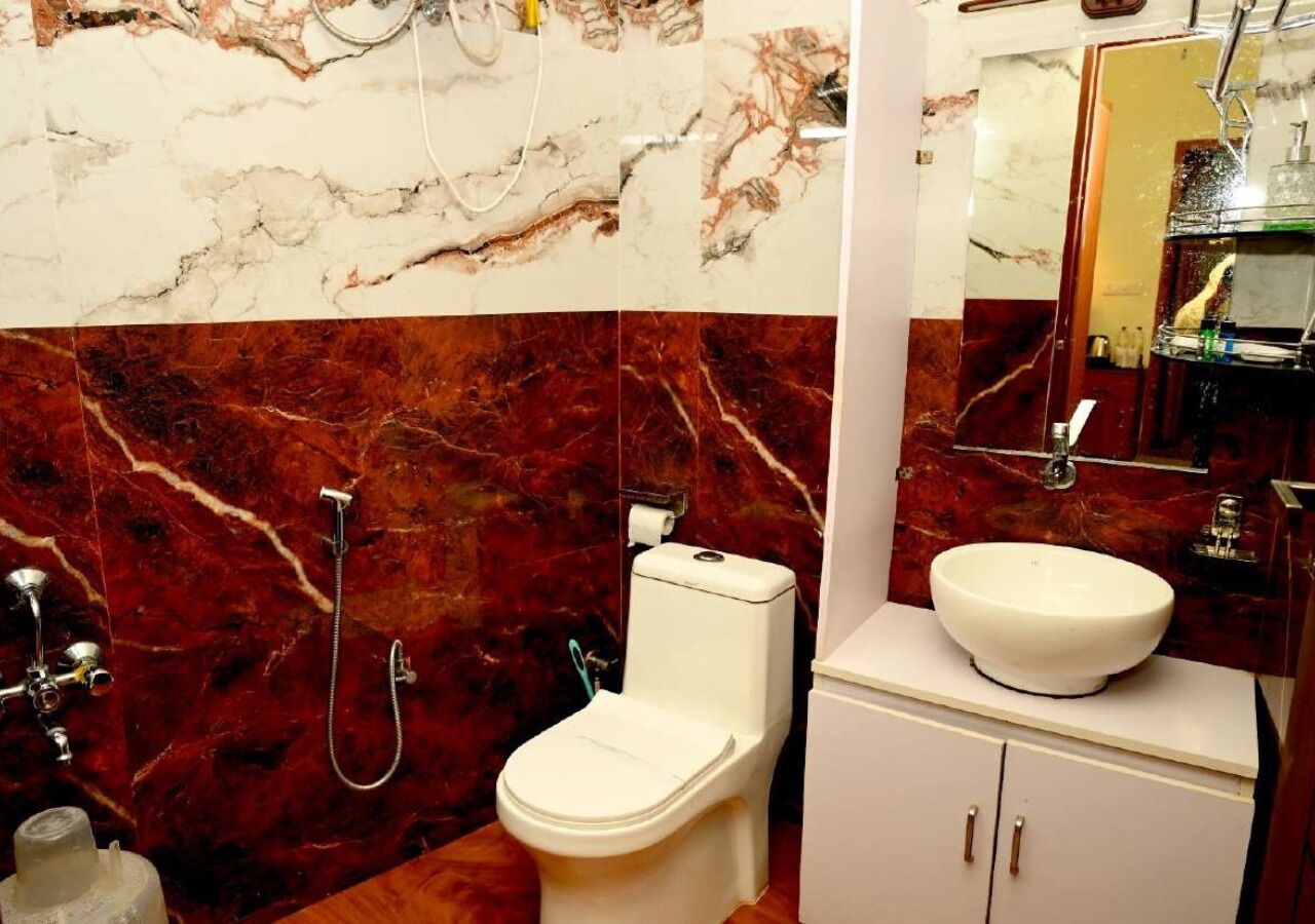 Un baño con inodoro, bidé y lavabo con espejo superior.