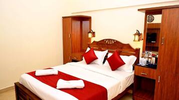 A neatly made bed with red and white bedding, wooden headboard, and bedside tables with lamps.
