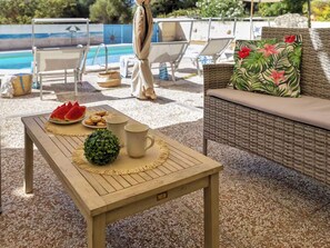 A wooden table with a placemat, a small green plant, a plate of watermelon slices, and two mugs. - Residence Il Ciliegio with swimming pool - Apartment 2 (Trinità d'Agultu e Vignola)