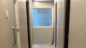 A hallway with a patterned floor, doors on either side, and a window at the end. - Hotel Taarini Rajwada Indore By LOTO (Indore)