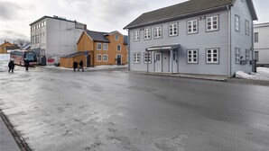 A building with a grey facade, a covered entrance, and a flat roof.