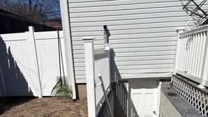 A concrete staircase leading to a door, surrounded by a white fence and a white building. - Private basement walkout in welcoming Huntington Station perfect for your stay (Huntington Station)