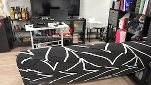 A room with a black and white patterned sofa, a television, a desk with a computer, a bookshelf, and a printer. - Private basement walkout in welcoming Huntington Station perfect for your stay (Huntington Station)