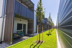 Een modern gebouw met een overdekt terras en een verzorgd gazon.