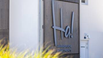 A sign for Harabruck Apartments with a modern design, featuring a large logo and the name of the property.