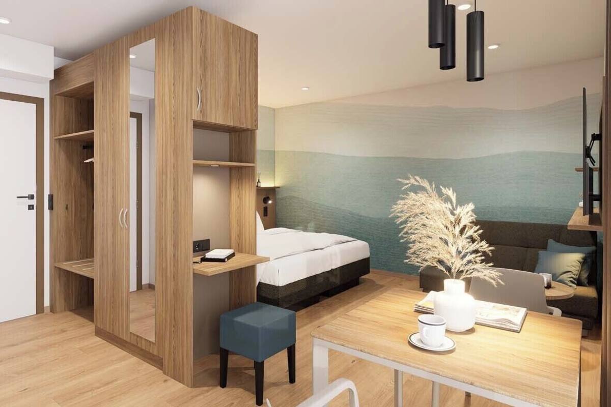Een moderne kamer met een bed, een bureau, een stoel, een bank en een muur met een landschapsdecoratie.