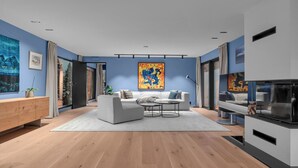 Ein modernes Wohnzimmer mit einer Couch, einem Couchtisch und Kunstwerken an den Wänden.