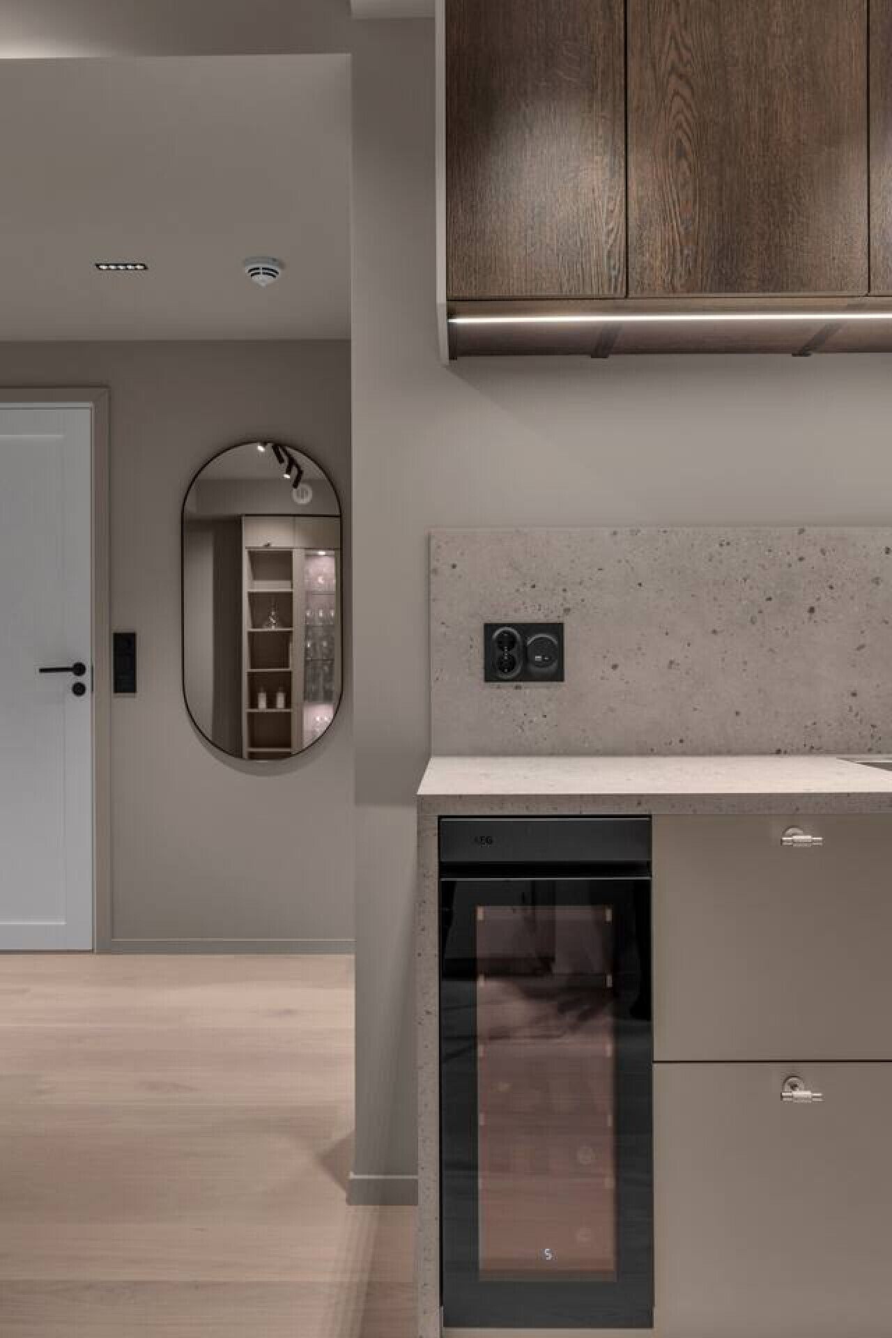 Una cucina moderna con lavastoviglie integrata, un mobiletto in legno sopra il bancone e uno specchio a parete.
