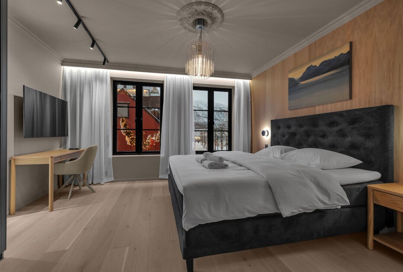 Una camera da letto moderna con un letto grande, una scrivania e una TV.