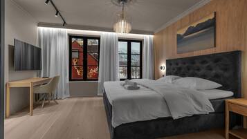 Una camera da letto moderna con un letto grande, una scrivania e una TV.