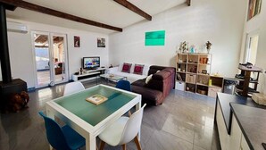 A spacious living area with a dining table, sofa, and a bookshelf. - "La Plagette" Baraquette near Etang, Clim (Sète)