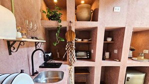 A compact kitchen with a sink, a stove, and a small refrigerator. - Villaggio Serra da Cantareira (Mairiporã)
