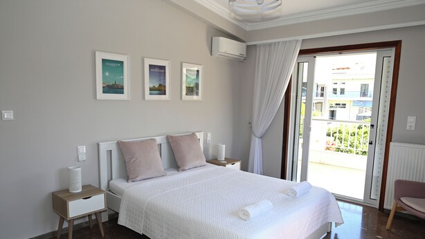 Un dormitorio con cama, mesitas de noche y vistas al exterior.