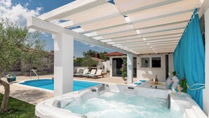A hot tub, a swimming pool, and lounge chairs under a pergola. - Villa Korana with heated Pool and Jacuzzi (Kamenmost)