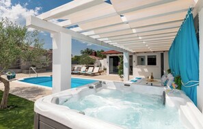 A hot tub, a swimming pool, and lounge chairs under a pergola. - Villa Korana with heated Pool and Jacuzzi (Kamenmost)