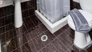 A bathroom with a shower, sink, toilet, and a mirror. - Hotel Thetis (Tolo)