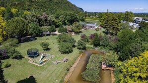 Ein Wohngebiet mit Fluss, Spielplatz und einem Haus mit großem Garten.