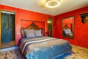 Une chambre avec un lit, une douche et un miroir.