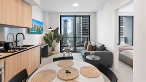 A modern apartment with a kitchen, dining area, and living room, featuring a city view through large windows. - Urban 1BR+Den | Gym | Spa | Downtown Miami (Miami)