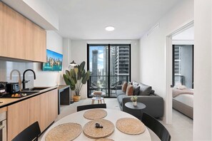 Eine moderne Wohnung mit Küche, Essbereich und Wohnzimmer, mit großem Fensterblick über die Stadt.