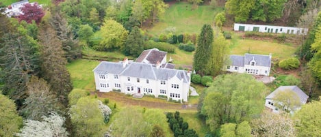 A large estate with multiple buildings surrounded by dense greenery.