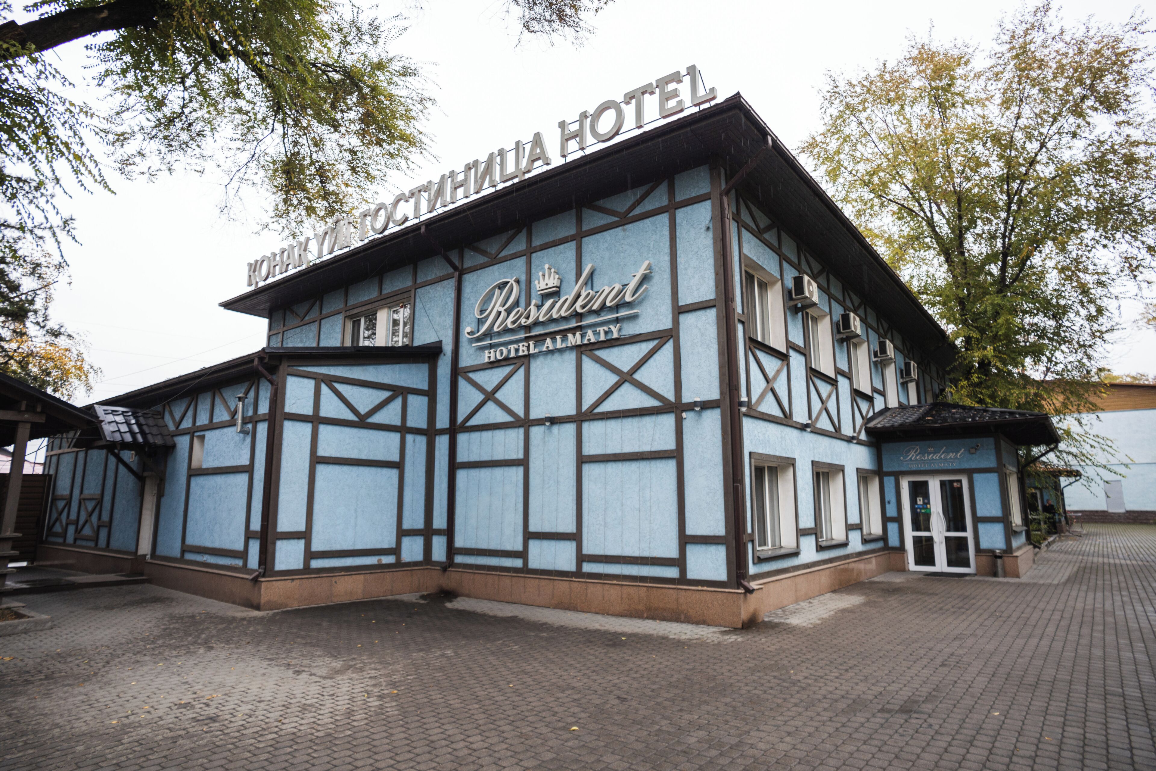 Un edificio tradicional con un cartel que dice 'Resident Hotel Almaty'.