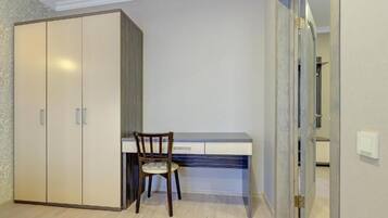 A bedroom with a wardrobe, a desk, and a chair.