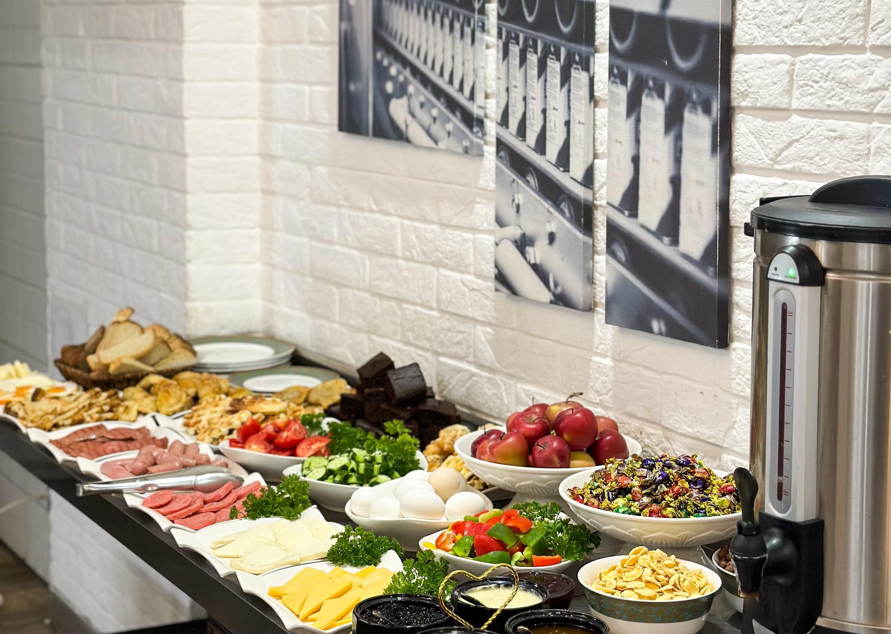 Buffet com diversos alimentos e uma cafeteira.