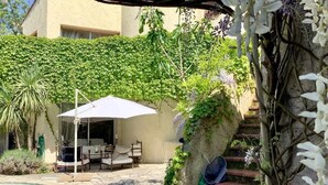 Un patio con piscina, mobiliario exterior y una escalera.