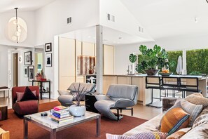 A modern living room with a sofa, chairs, a coffee table, and a dining area with a table and chairs. - El Cid Social - A Bold, Retro‑Chic Palm Springs Escape with Pool, Mountain Views, & BBQ Grill (Palm Springs)