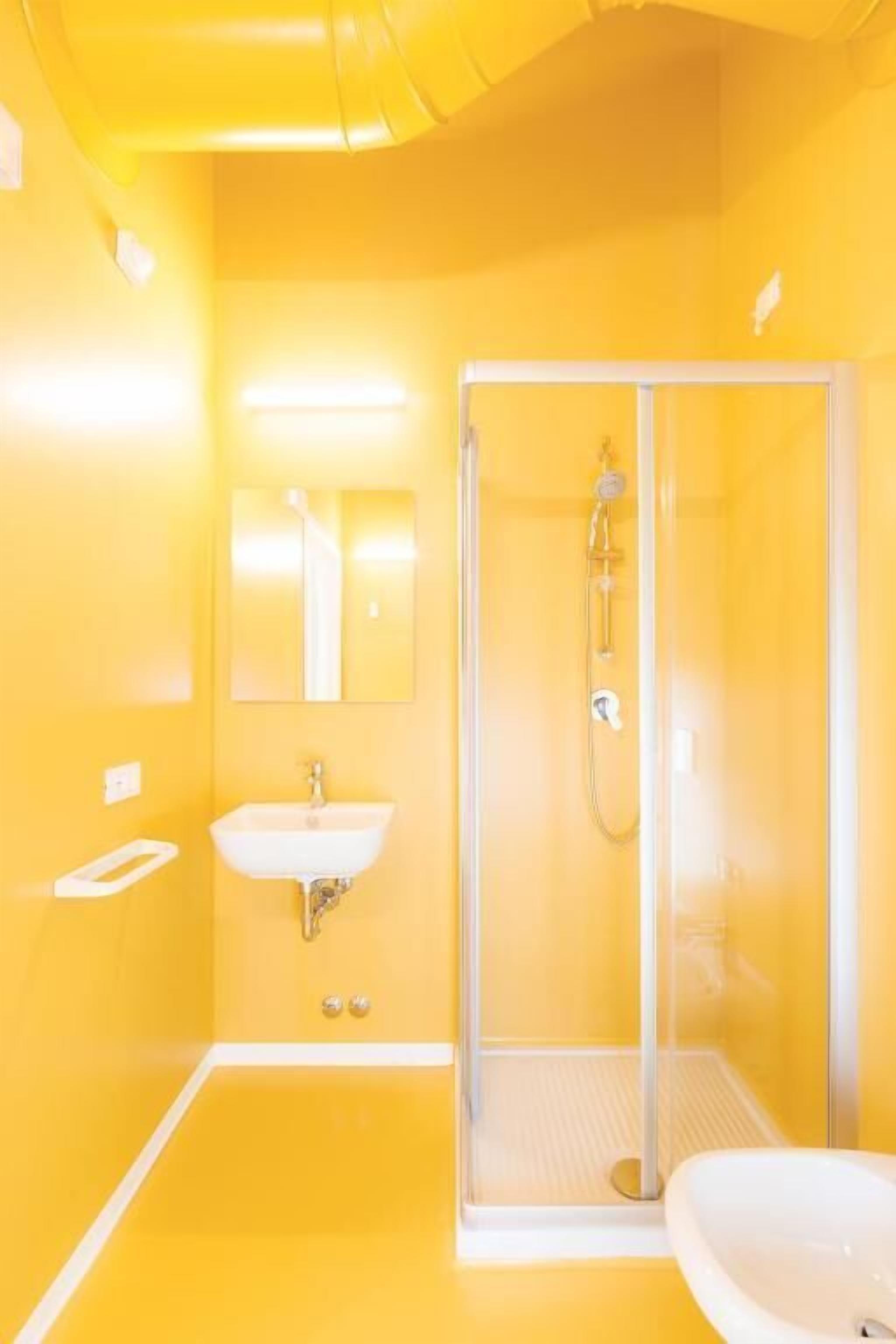 A bathroom with a glass shower enclosure, a sink, and a mirror.