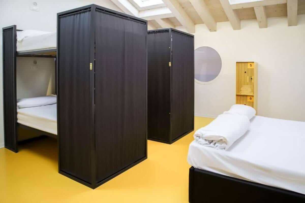 Une pièce avec des lits superposés, une décoration murale circulaire et une étagère en bois.