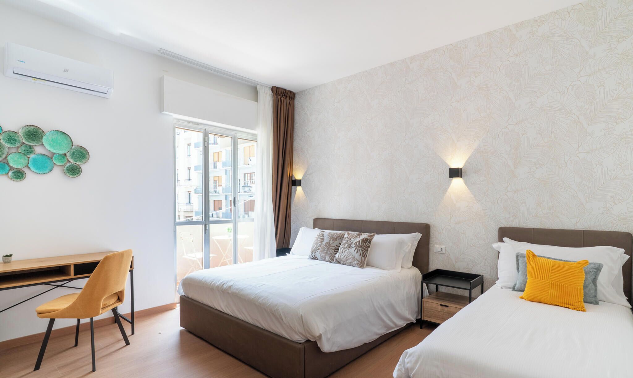 A hotel room with a bed, a desk, and a chair.