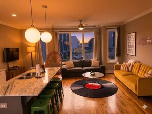 A modern living room with a sofa, coffee table, and a vinyl record centerpiece. - Rooftop Skyline View-Close to Broadway-Sleeps 8 (Nashville)