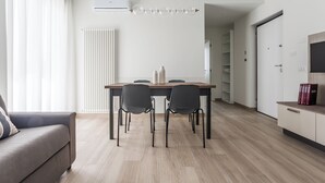 A modern living room with a dining table, chairs, a sofa, and a TV. - Residenze Vesuviane - Pompei (Terzigno)