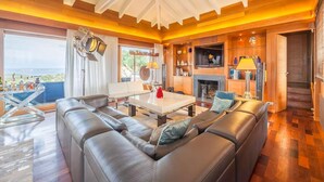 A modern living room with a large leather sofa, a dining table, and a fireplace. - Villa Carla (Bonifacio)