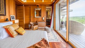 A bedroom with a bed, a chair, a desk, a mirror, and a large window. - Villa Carla (Bonifacio)