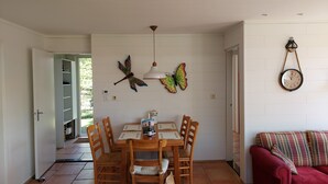 A dining area with a table, chairs, and butterfly wall art. - Ferienhaus "Datscha" Oostkapelle,  Zeeland,  NL
Familienurlaub (Oostkapelle)