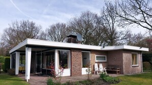 A modern house with a covered patio, a brick chimney, and a garden. - Ferienhaus "Datscha" Oostkapelle,  Zeeland,  NL
Familienurlaub (Oostkapelle)