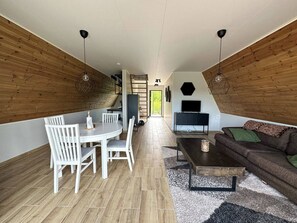 Ein moderner Loft-Wohnraum mit Essbereich, einer Couch und einem Fernseher.