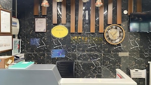 A reception desk with a clock, framed certificates, and a plaque on the wall.